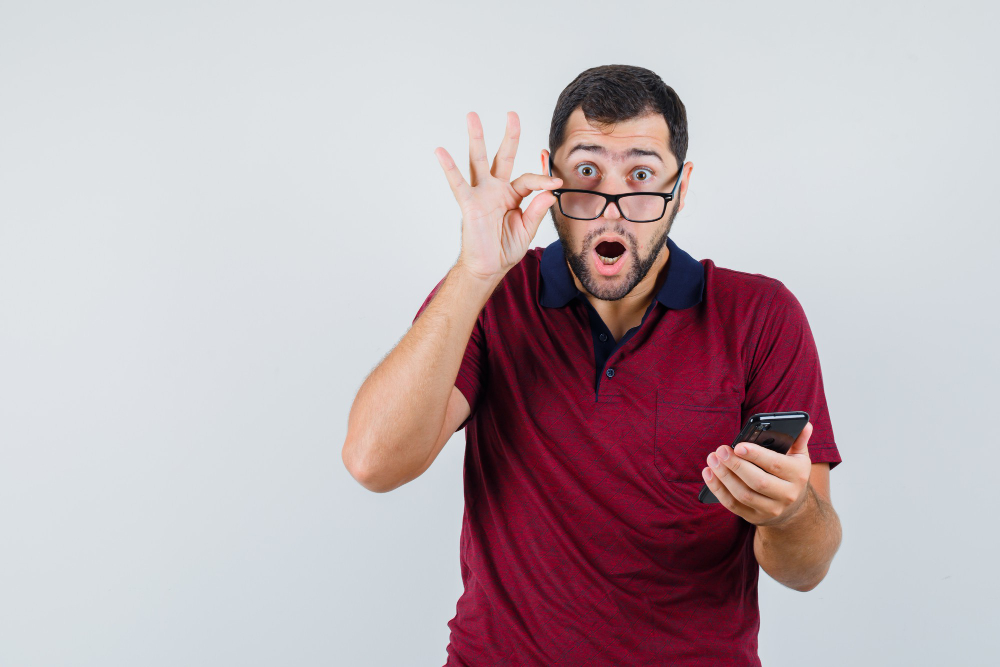 Hombre sorprendido al leer una noticia en su teléfono móvil